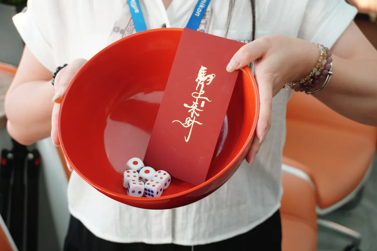 Dice and a festive red envelope during Apter Power's Bobing celebration